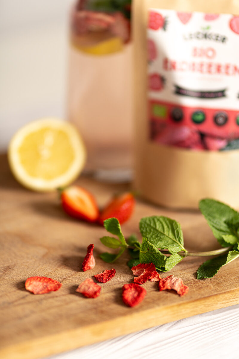 Gefriergetrocknete Erdbeeren liegen auf einem Holzbrett