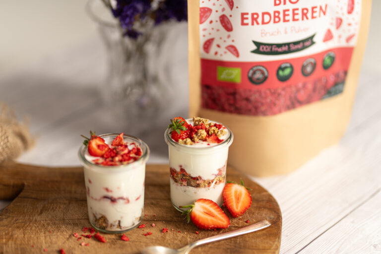Gefriergetrocknete Erdbeeren Packung Bruch neben einem Holzbrett mit Deko