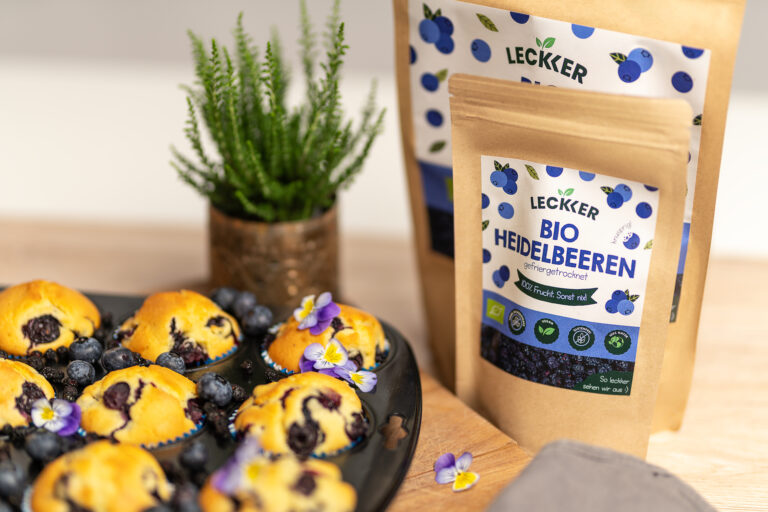 Gefriergetrocknete Blaubeer Packungen neben Blaubeermuffins