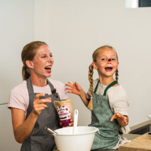 Mutter und Tochter beim Backen mit gefriergetrockneten Himbeeren