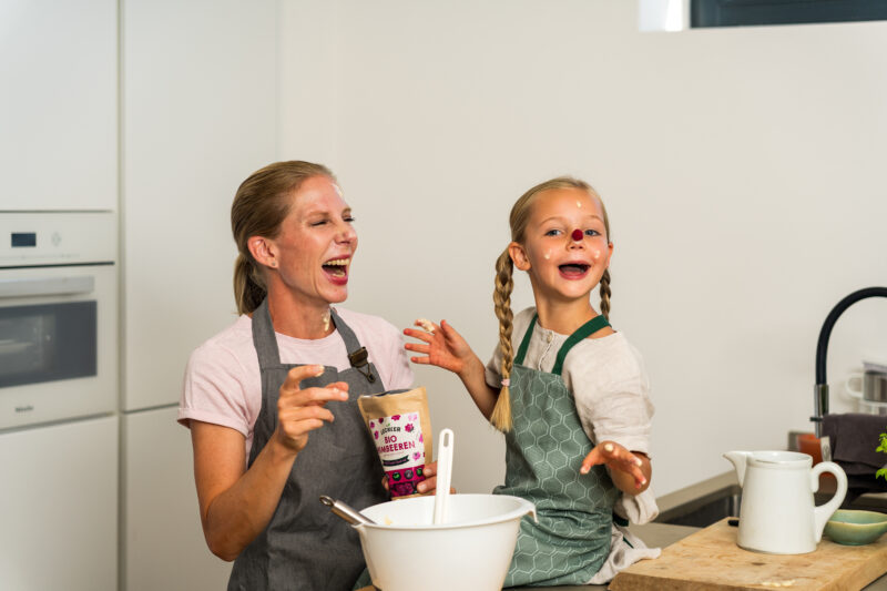 Mutter und Tochter beim Backen mit gefriergetrockneten Himbeeren