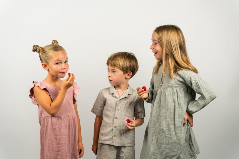 3 Kinder mit gefriergetrockneten Himbeeren