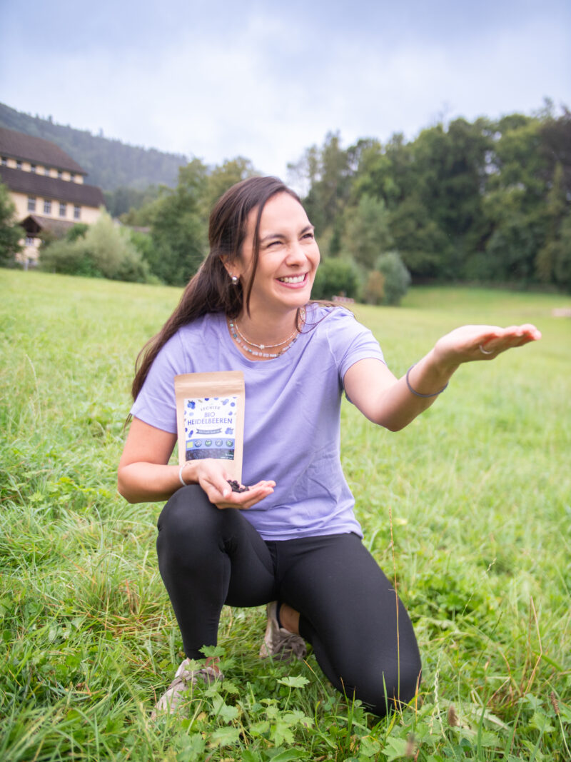 Frau mit gefriergetrockneten Heidelbeeren