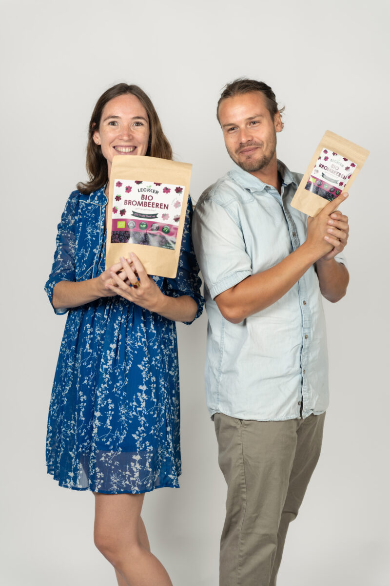 Mann und Frau mit gefriergetrockneter Brombeeren Packung