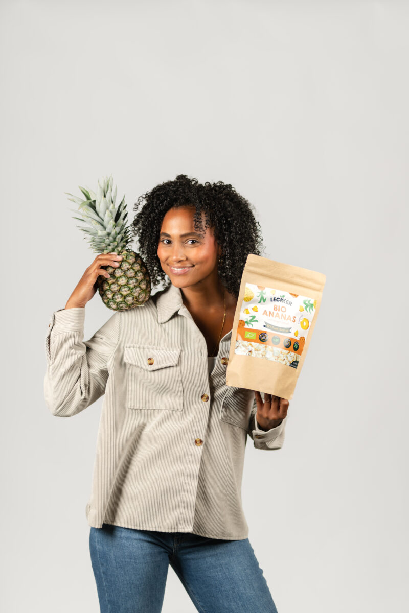 Frau mit gefriergetrockneter Ananas und Ananas