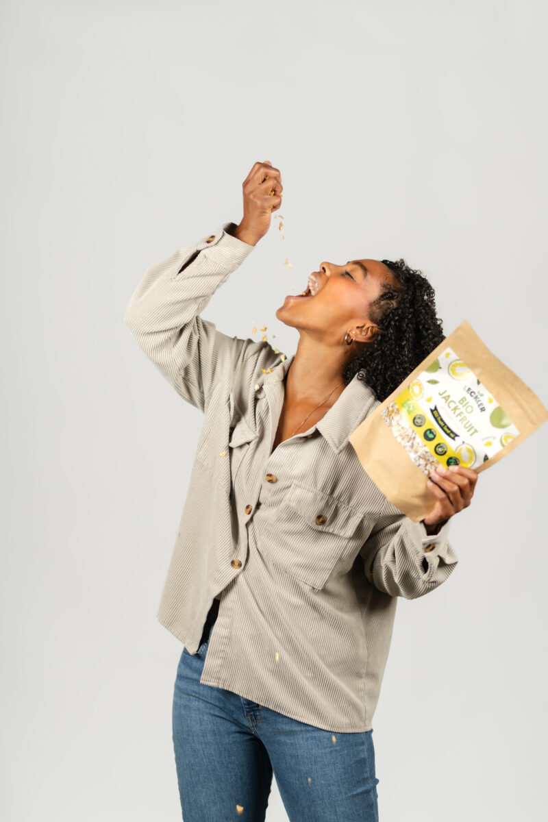 Frau isst gefriergetrocknete Jackfruit