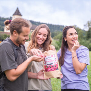 3 Menschen beim Wandern mit gefriergetrockneten Erdbeeren