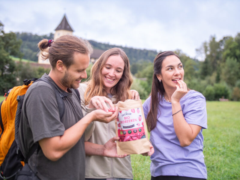 3 Menschen beim Wandern mit gefriergetrockneten Erdbeeren